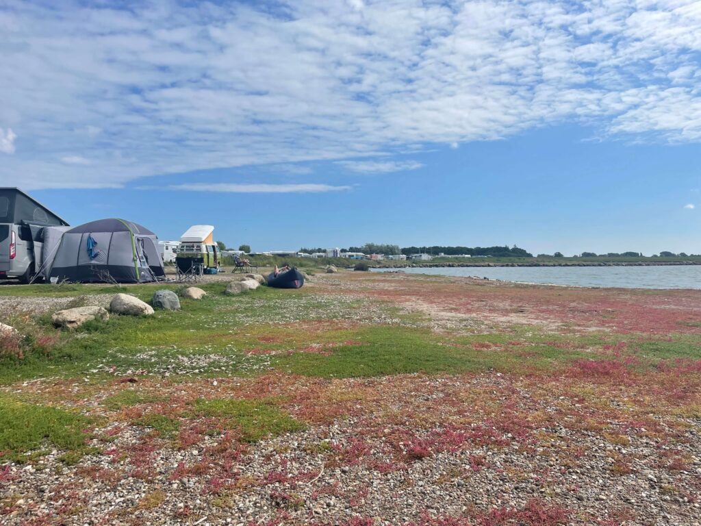 Blauer Himmel mit weißen Wolken, Campingbusse und ein Binnensee